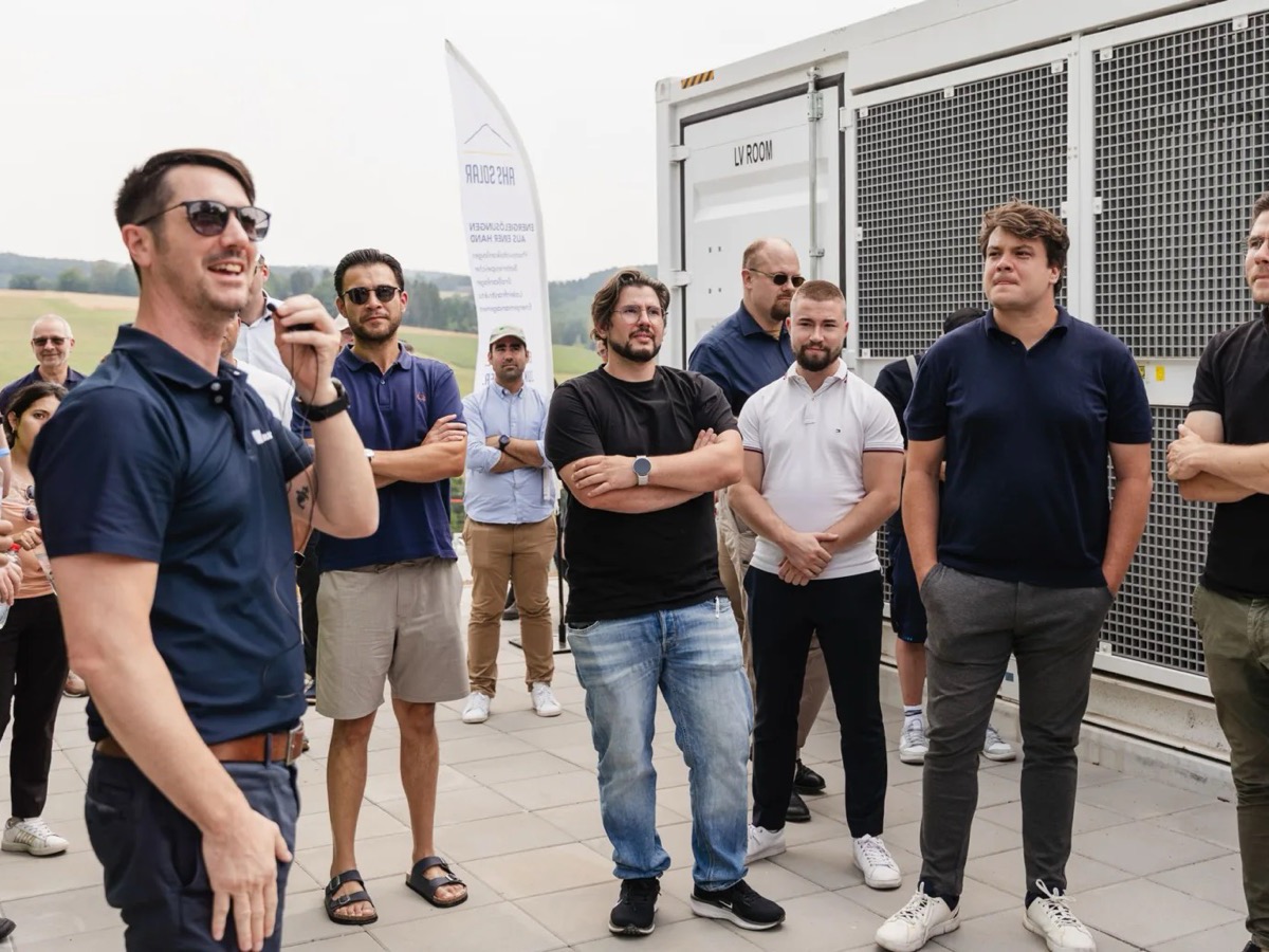 Teilnehmer der Führung vor einem Speichercontainer im Solarpark, in der Mitte Marco Grünberger